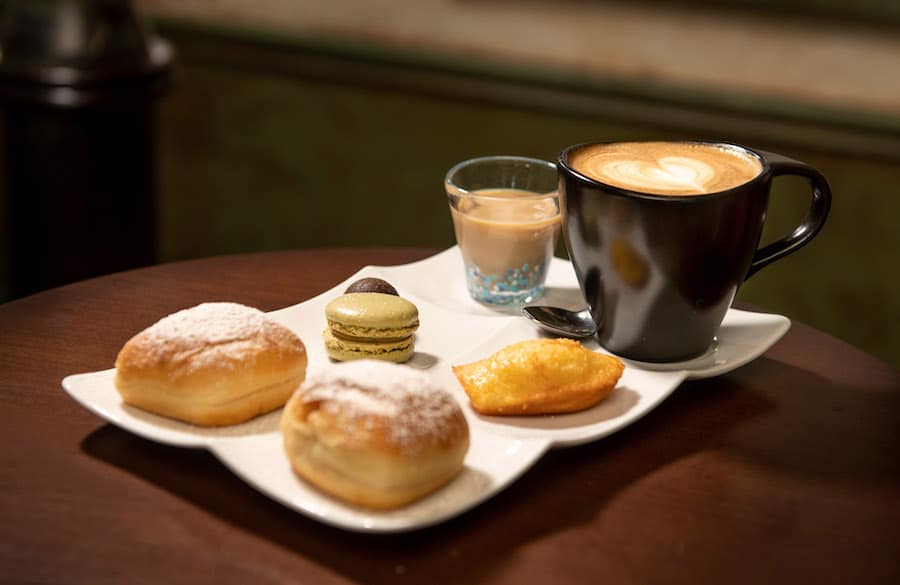 Cappuccino, macaron, pastries, chocolate, and liqueur—like treats you'd find at a Disney park café or onboard the Disney Wonder.