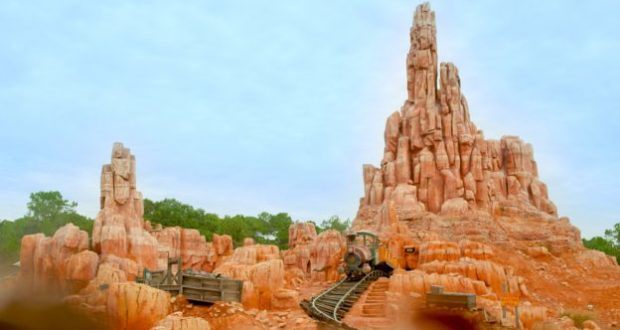 Big Thunder Mountain Railroad’s runaway mine train speeds along twisting tracks past iconic red rocks at Walt Disney World.