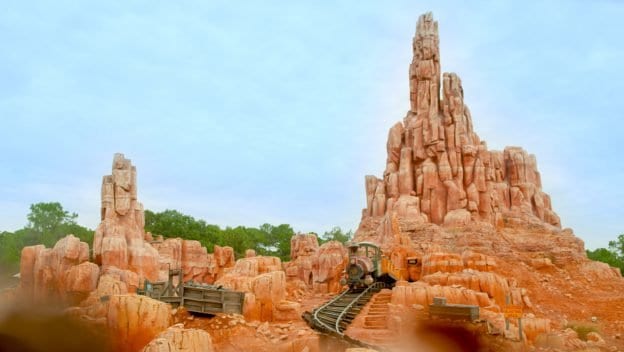 Big Thunder Mountain Railroad’s runaway mine train speeds along twisting tracks past iconic red rocks at Walt Disney World.