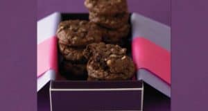 Ghirardelli double chocolate nut cookies stacked in a festive box with pink and purple paper, perfect for a Disney treat stand.