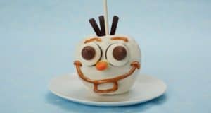 Olaf Candy Apple at Disney parks, featuring white coating and chocolate accents, is a must-try Frozen-themed treat.