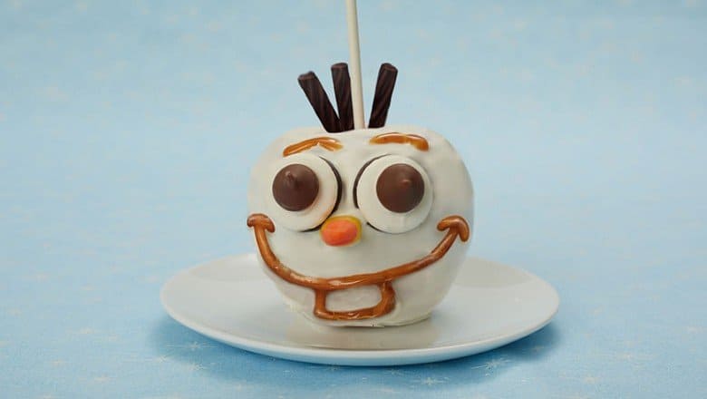 Olaf Candy Apple at Disney parks, featuring white coating and chocolate accents, is a must-try Frozen-themed treat.