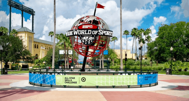The iconic ESPN Wide World of Sports globe welcomes guests at the Complex entrance, framed by palm trees and vibrant energy.