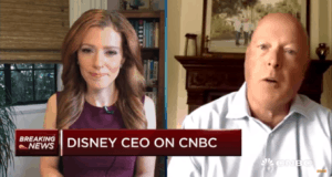 Two people video chatting; CNBC banner says "Disney CEO interview" with "Breaking News" about changes to the Disney parks experience.