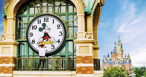 Mickey Mouse adjusts a giant clock on a balcony near Shanghai Disneyland's fairytale castle, revealing exclusive behind-the-scenes magic.