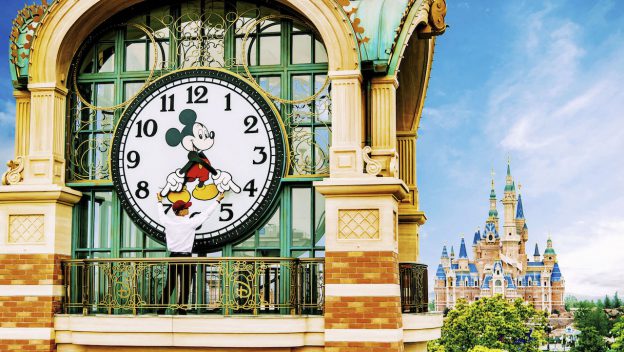 Mickey Mouse adjusts a giant clock on a balcony near Shanghai Disneyland's fairytale castle, revealing exclusive behind-the-scenes magic.