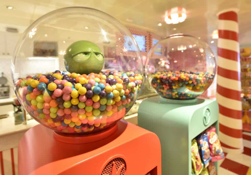 Giant gumball machines from Disney Cruise Line’s Cruise Series, featuring a green character face in a globe of colorful candy.