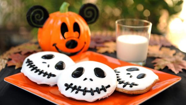 Jack Skellington cookies on an orange plate with milk and a pumpkin jar—ideal for Disney Halloween fans or Halfway2Halloween.