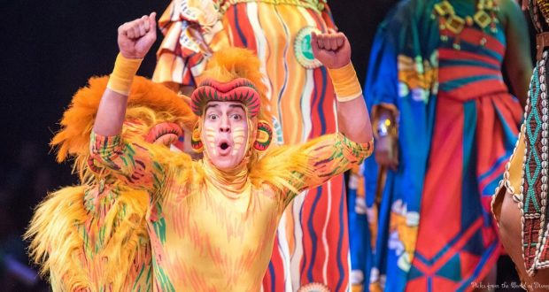 A lively Lion King performer in a vibrant lion costume wows the crowd at Disney’s Festival of the Lion King stage spectacular.