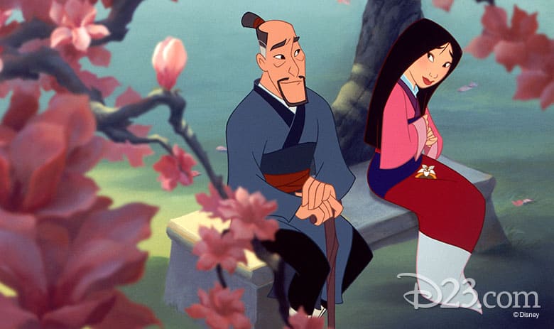 Mulan and her father share a touching moment on a stone bench beneath Disney Parks’ cherry blossoms, capturing classic family magic.