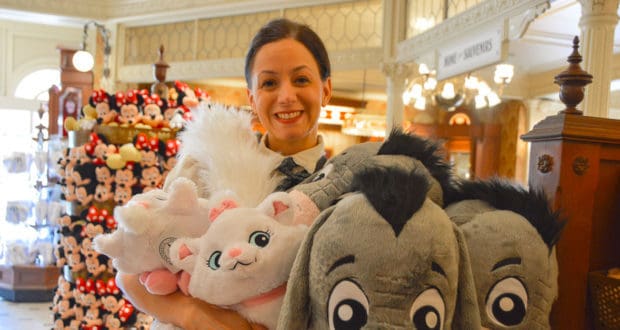 Disney fan beams with excitement while shopping for oversized plush Mickey and friends at Walt Disney World's vibrant gift shop.