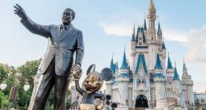 The iconic Partners statue of Walt Disney and Mickey Mouse greets guests in front of Cinderella Castle at Disney World.