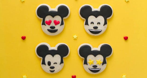 Four Mickey Mouse emoji cookies on a yellow background with hearts and stars—Disney magic for fans and party inspo!.