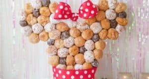 Discover how to create a magical Minnie Donut Tower, inspired by Disney parks, stacked with Minnie-shaped donuts and a red polka dot bow.