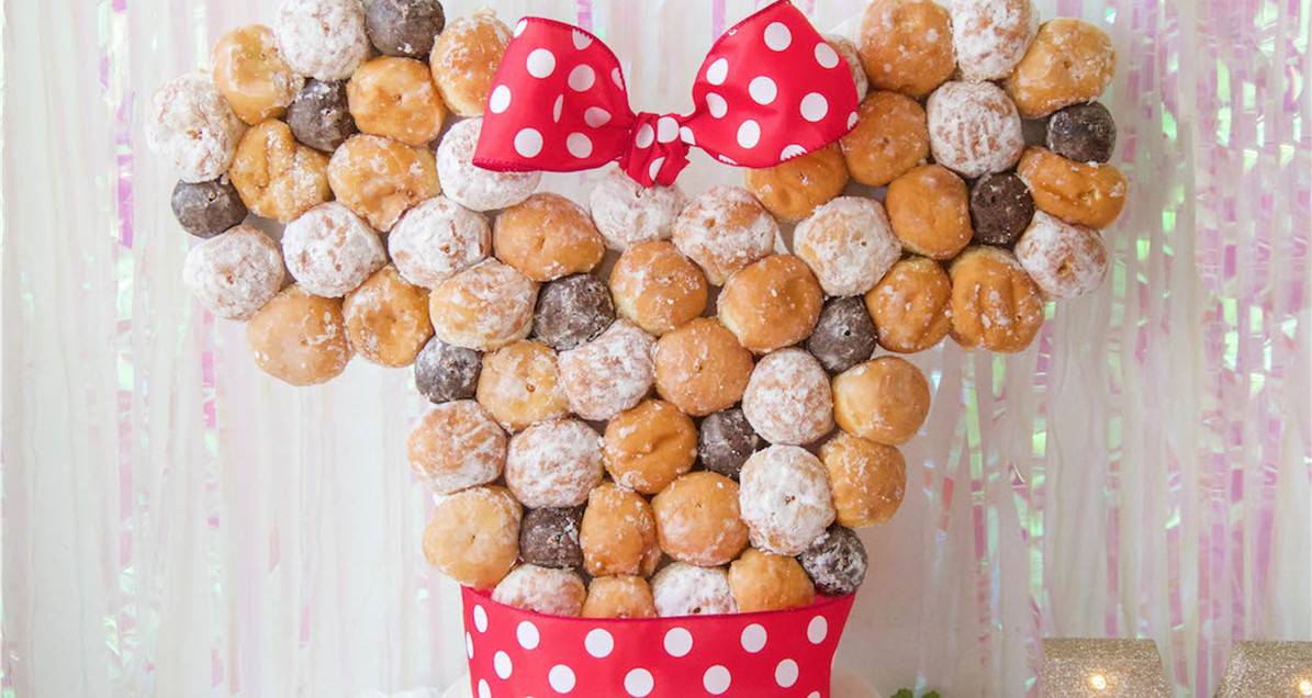 Discover how to create a magical Minnie Donut Tower, inspired by Disney parks, stacked with Minnie-shaped donuts and a red polka dot bow.