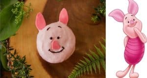 Piglet-themed donut alongside Piglet artwork on rustic wood, perfect for Disney dessert fans seeking Pooh-inspired treats.