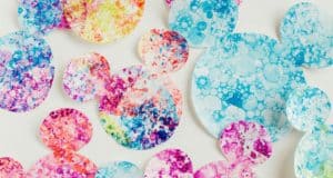 Vibrant, bubble-inspired Mickey circles in assorted sizes pop across white, echoing the playful spirit of Disney parks.