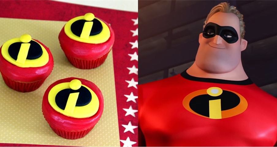 Mr. Incredible cupcakes topped with The Incredibles logo displayed beside Mr. Incredible at Pixar Pier, perfect for super fans.