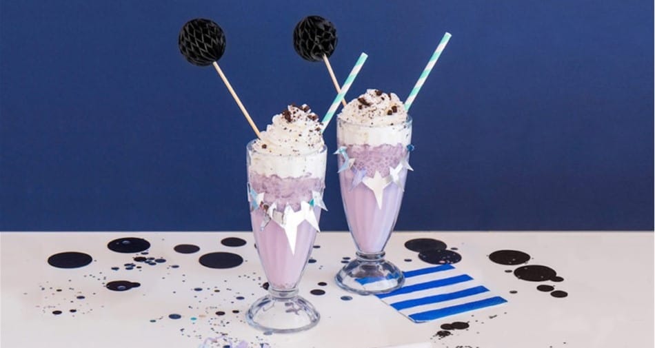Enjoy two Black Panther-inspired purple milkshakes with whipped cream and sprinkles, perfect for your next Marvel park adventure!.