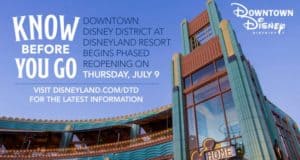 Downtown Disney’s entrance welcomes guests back July 9, highlighted by reopening banners beneath a clear blue sky.