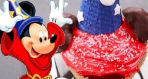 Mickey as the Sorcerer's Apprentice poses by a colorful cupcake, bringing Disney magic to your day at the park.