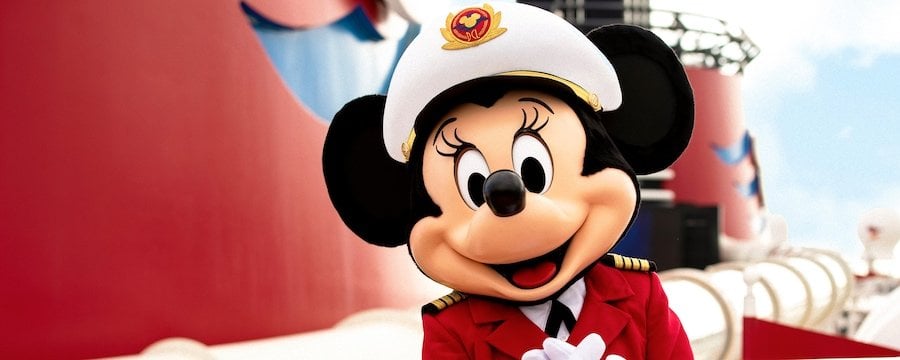 Minnie Mouse, dressed as captain in her red uniform, greets Disney Cruise Line guests, ready to start the magical voyage.