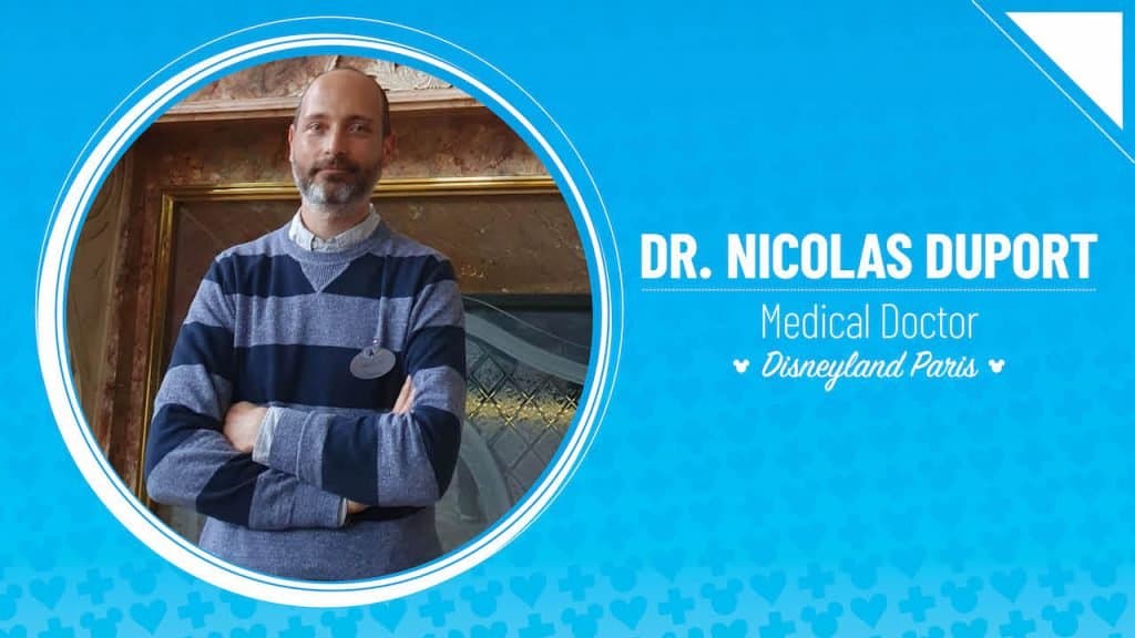 Dr. Nicolas Duport, in a striped sweater with arms crossed, represents Disneyland Paris’ commitment to Cast Member wellbeing.