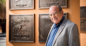 A Disney fan poses in front of the Marty Sklar Disney Legend plaque, celebrating the legacy of Imagineering at the park.