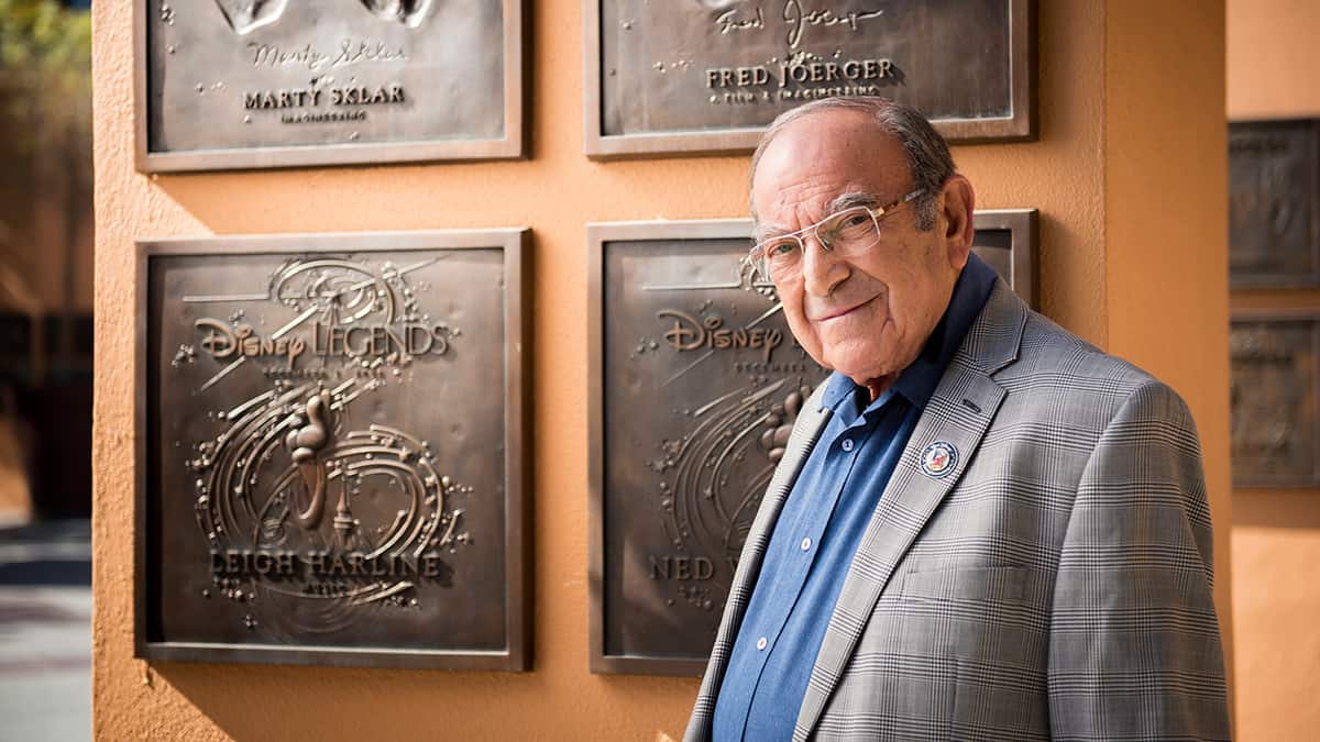 A Disney fan poses in front of the Marty Sklar Disney Legend plaque, celebrating the legacy of Imagineering at the park.
