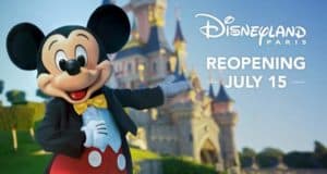 Mickey Mouse greets guests in front of Disneyland Paris castle, with “Reopening July 15” signage welcoming everyone back.
