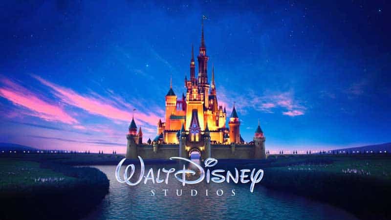 The iconic Disney castle aglow under a twilight sky, with "Walt Disney Studios" text, captures the wonder of Disney parks.