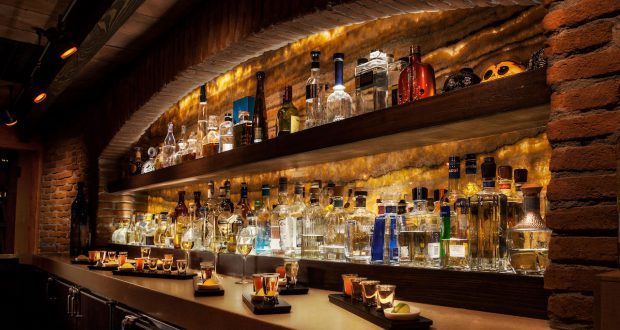 Backlit liquor shelves and trays of drinks at an EPCOT bar—one of Disney World’s must-see hidden gems for park fans.