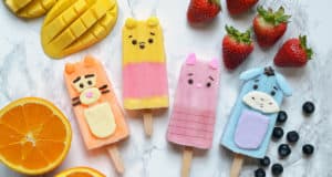 Whimsical animal popsicle treats with fresh fruits await at the snack cart on Main Street—ideal for your next theme park adventure!.