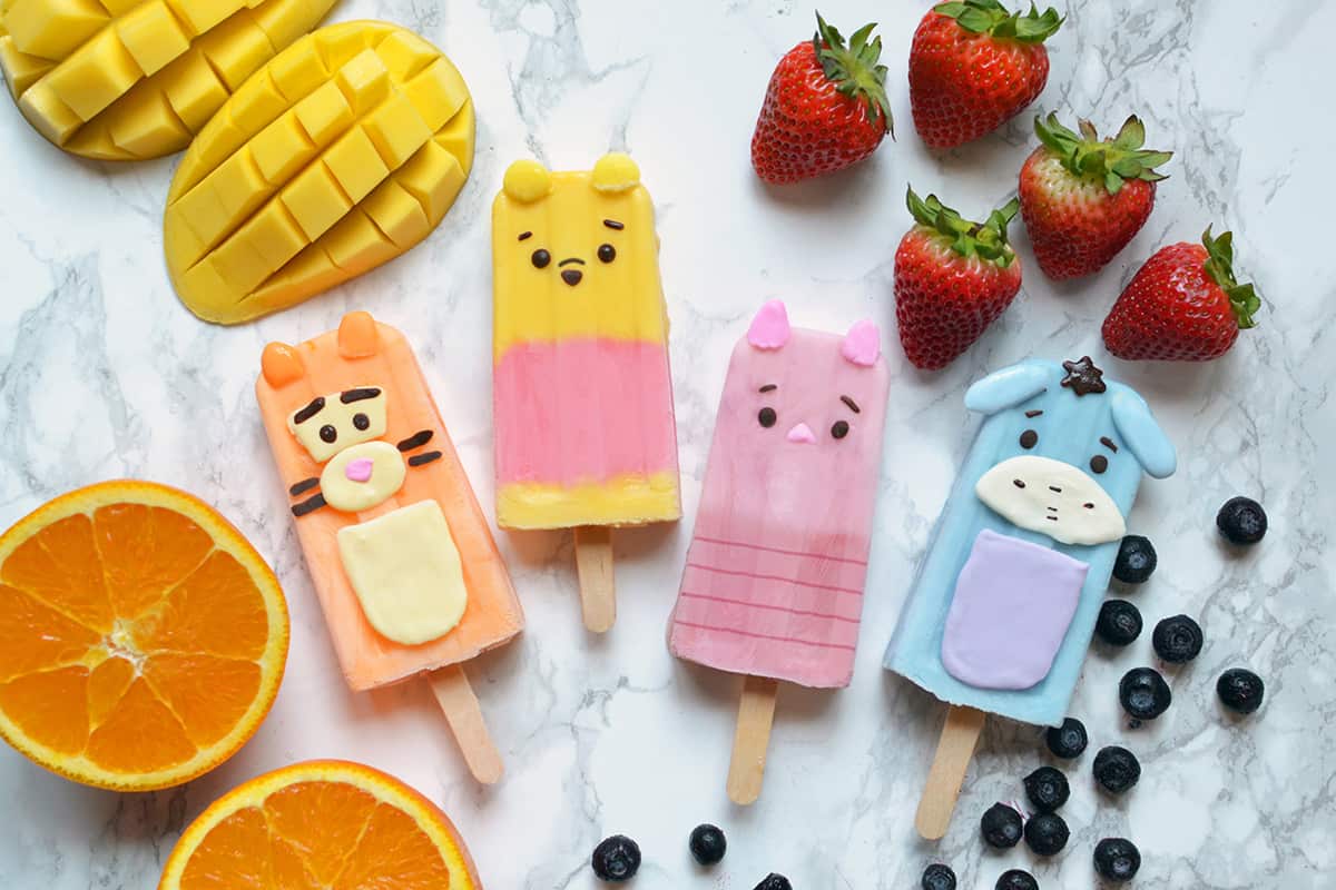 Whimsical animal popsicle treats with fresh fruits await at the snack cart on Main Street—ideal for your next theme park adventure!.