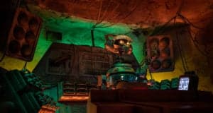 DJ R-3X spins tunes in Oga’s Cantina’s neon-lit control booth, surrounded by colorful panels—Star Wars: Galaxy’s Edge magic!.