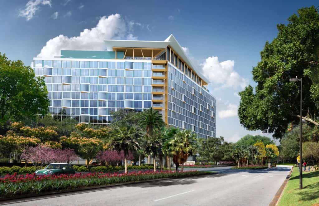 Swan & Dolphin-inspired glass hotel with yellow accents, set by a broad road amid trees and flowers, marks new Disney magic.