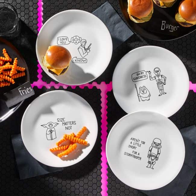 Corelle’s Star Wars plates, each showcasing exclusive designs from the saga, are set out with themed sliders and waffle fries on a black table marked by vibrant pink grid lines—perfect for fans looking to bring a bit of Galaxy’s Edge energy into their dining experience.