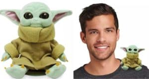 A guest beams with a Baby Yoda Magnetic Shoulder Plush perched on his shoulder, the adorable Star Wars character in a tan coat, available at shopDisney.