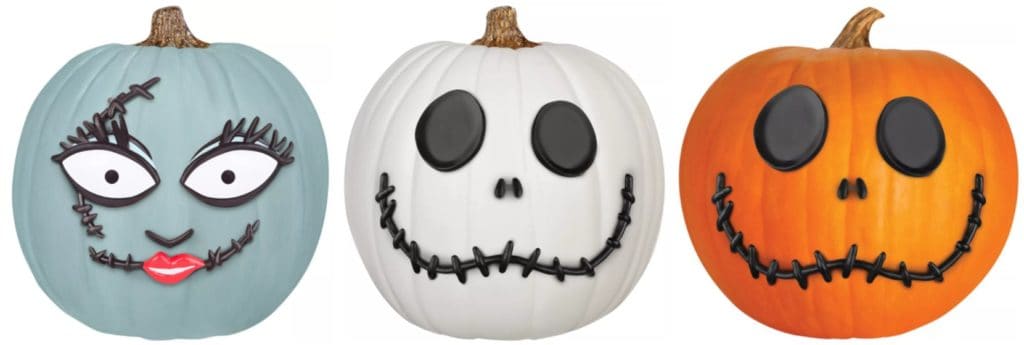 Three pumpkins styled as whimsical characters with exaggerated eyes and stitched grins, each painted in unique colors reminiscent of the playful spirit of Halloween Town—an ideal decoration for fans of The Nightmare Before Christmas visiting theme park seasonal events or seeking creative, no-carve pumpkin activities featured at Target.
