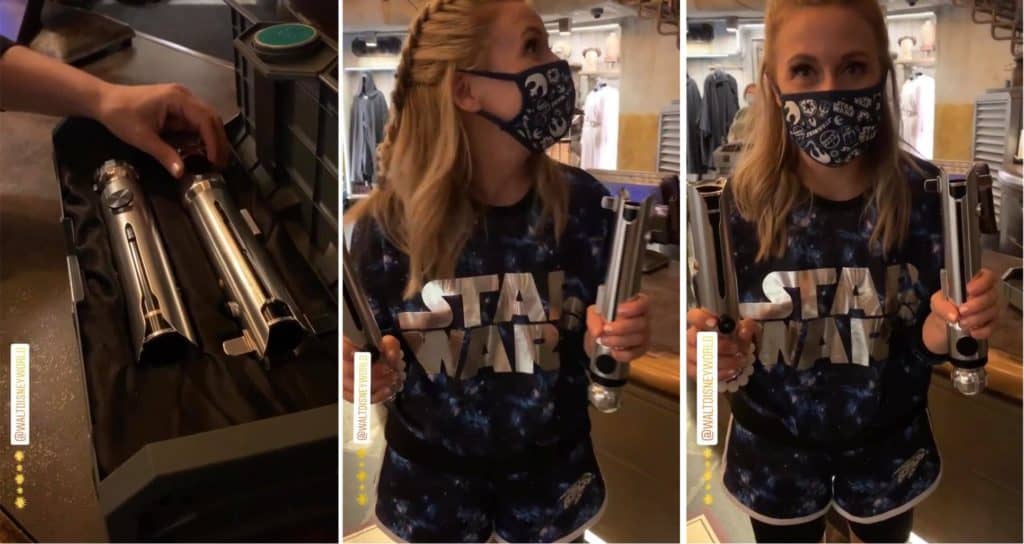 A Star Wars fan in themed attire wields Legacy Lightsabers at Galaxy’s Edge, immersed in the outpost’s interactive shop.