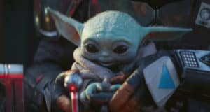Grogu, the beloved green character with big ears and wide eyes from The Mandalorian, is cradled by Din Djarin in his unmistakable Mandalorian armor, bringing to life a fan-favorite moment from the hit Disney+ series recognized at Star Wars: Galaxy’s Edge.