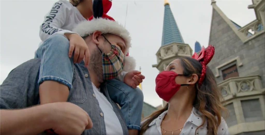 Guests don festive masks and accessories, sharing joyful smiles in front of iconic castle architecture, embodying the magic and holiday excitement of Walt Disney World.