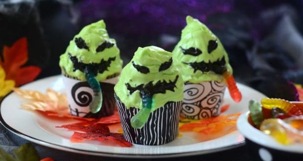 Halloween cupcakes designed like green monsters with gummy worm decorations, served on a white plate—imagine these festive treats featured at Universal Studios’ Halloween Horror Nights, adding a sweet touch to the spooky park festivities.