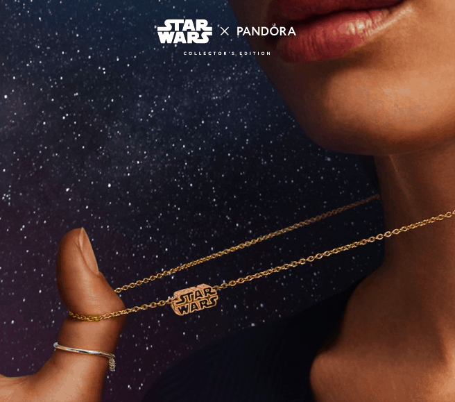 A Star Wars gold necklace from Pandora is displayed against a galaxy-inspired backdrop, with Pandora branding adding to the collectible appeal for fans of themed entertainment.