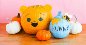 Winnie the Pooh and his iconic "Hunny Pot" come to life on these delightfully themed pumpkins, channeling all the charm of a fall celebration at a Disney park, with smaller decorative pumpkins accenting the festive scene.