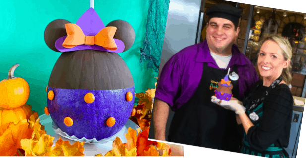 A Halloween Minnie Witch Caramel Apple is showcased at Disneyland Resort, with two happy guests posing together—one holding the festive treat—surrounded by whimsical pumpkin decorations and Halloween-themed décor.