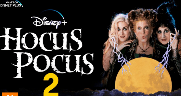 Winifred, Sarah, and Mary Sanderson, the iconic witches from Hocus Pocus—portrayed by Bette Midler and cast—stand dramatically before a glowing full moon. The "Hocus Pocus 2" title and Disney+ logo appear on the left, spotlighting Disney's magical return of the beloved Halloween classic.