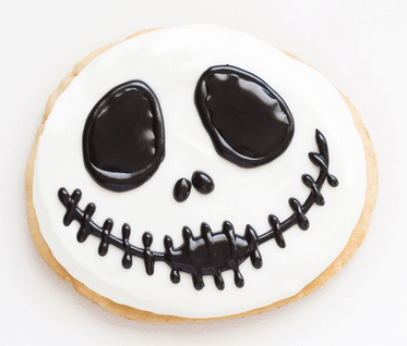 Jack Skellington sugar cookie from "The Nightmare Before Christmas," decorated with white and black icing, just like the treats served at Disney Parks during Halloween celebrations—ideal for adding a magical, spooky flair to your festive snack lineup.