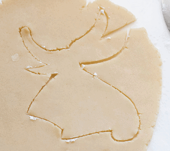 Sugar cookie dough with an angel-shaped cutout, leaving a playful silhouette in the rolled-out dough—ideal for recreating that magical Tim Burton flair at your next Halloween party, or for guests wanting to bring some The Nightmare Before Christmas fun to their themed baking adventures.