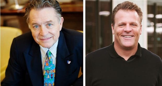 Two smiling men—one dressed in a classic suit with a vibrant Disney-inspired tie, the other in a sleek black shirt—stand together inside during an industry event, possibly reminiscing about their days bringing Disney magic to guests or discussing behind-the-scenes stories and strategies from post-Disney careers at fan-favorite panels.